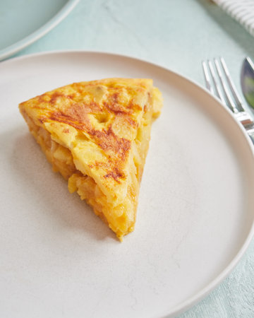 A portion of delicious and juicy Spanish potato omelette served on a plate.の写真素材