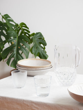 minimalist table with tablecloth, tableware and glasswareの写真素材