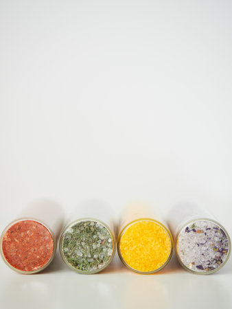 Flavor and color concept. Close-up view of bottom of round glass jars with different types of sea salt flavoured. Copyspace.の写真素材