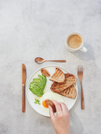 Breakfast with toast, avocado, egg and coffee on gray background
