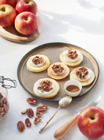 Homemade cinnamon rolls with apples and pecans on a trayの写真素材