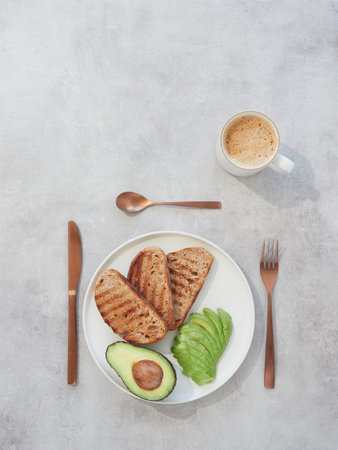 plate with avocado and toasted bread for breakfast or brunch served with a cup of coffeeの写真素材
