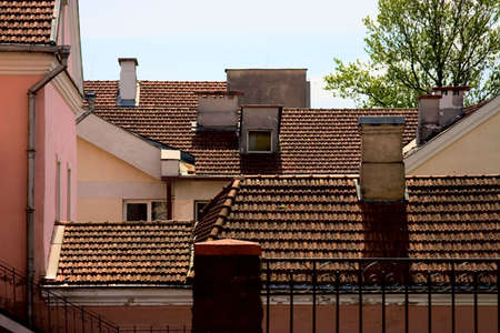 Tile roofs of the old houses with chimneiesの写真素材