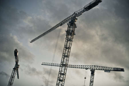 Lifting cranes against cloudsの写真素材