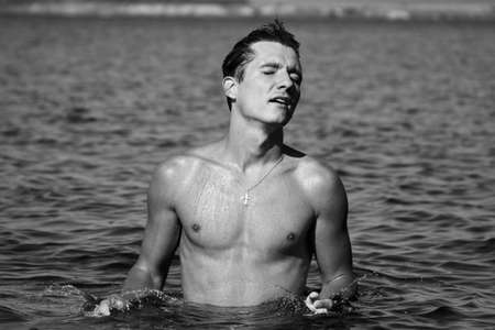 Wet man in the water with closed eyesの写真素材