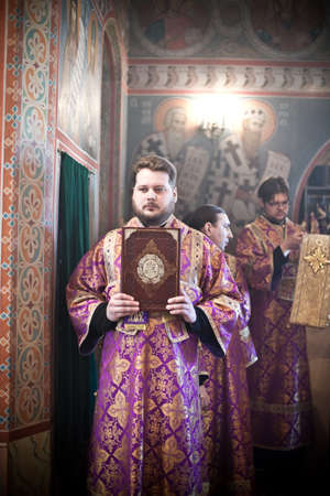 Deacon in gold and violet robe  stands with a holy book. Orthodox liturgy with bishop Mercury in High Monastery of St Peter in Moscow on March 14, 2010 in Moscowのeditorial素材