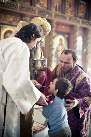 Orthodox bishop gives communion to a little boy. Orthodox liturgy with bishop Mercury in High...