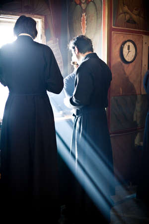 Two monk eat after the Liturgy near the window full of light. Orthodox liturgy with bishop Mercury in High Monastery of St Peter in Moscow on March 14, 2010 in Moscow Two monk eat after the Liturgy near the window full of light. Orthodox liturgy with bishop Mercury in High Monastery of St Peter in Moscow on March 14, 2010 in Moscow