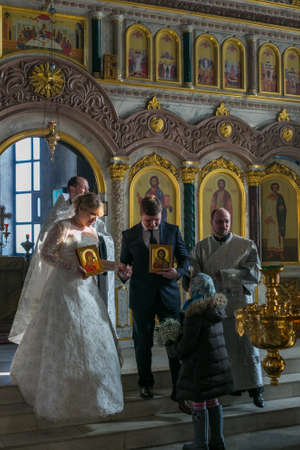 MOSCOW - MARCH 10: bride and groom carry icons during orthodox wedding ceremony on March 10, 2013 in Moscowのeditorial素材
