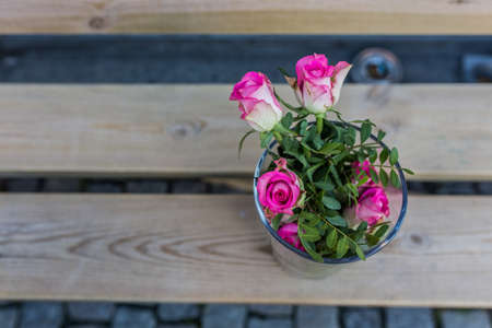 Beautiful pink bouquet flowers standing in vase on benchの写真素材