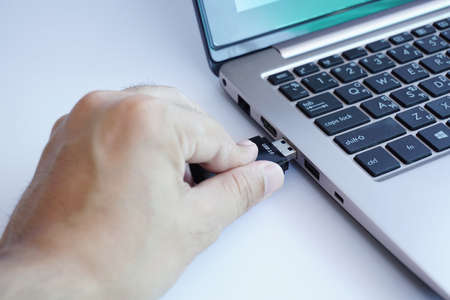 Hand plugging usb card reader to laptopの写真素材