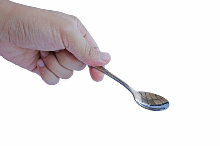 Hand holding empty spoonの写真素材