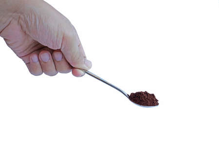 Hand holding a spoon with coffeeの写真素材