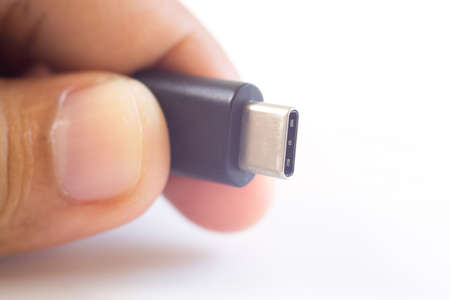 close up hand holding usb type c connector on white backgroudの写真素材