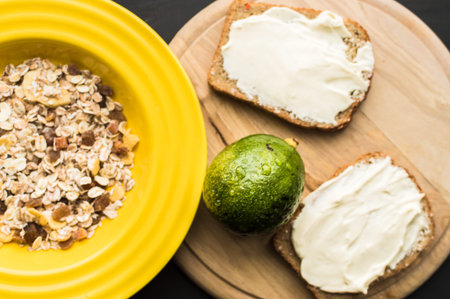 Helpful breakfast - fried egg, poached eggs, avocado, apple, muesli and orange juice on light...