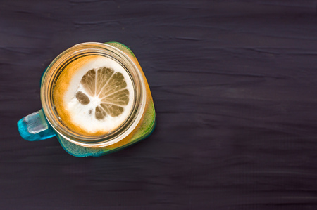 water with lemon in a glass jar on a dark background. concept detoxの写真素材