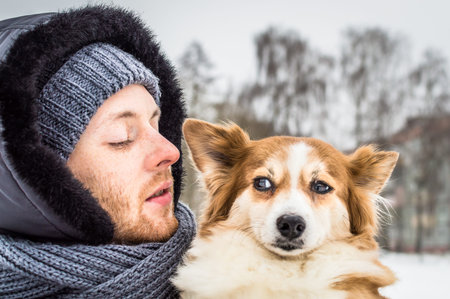 portrait of a young man and a dog close-up. concept dog and man. suspicious look of a dogの写真素材