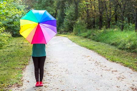 Young woman with bright multi-colored umbrella. Concept optimism and happinessの写真素材