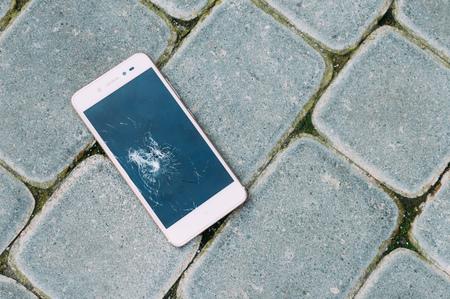 Smartphone with a broken display lies on the road. Concept repair of mobile phones.の写真素材