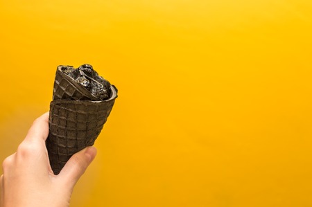 Fashionable black ice cream on a yellow background.の写真素材