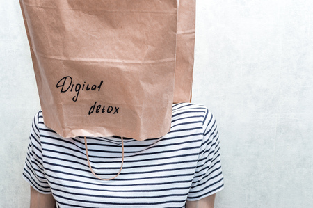 man with a paper bag on his head and an inscription digital detox.の写真素材