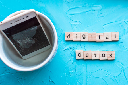 Concept digital detox. Smartphone in a mug with waterの写真素材