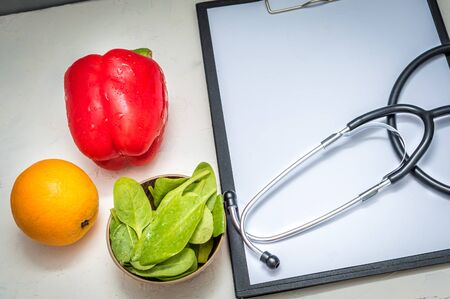 Healthy products and stethoscope on table in nutritionist's office. Close upの写真素材