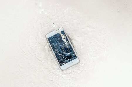 Phone in the water. Concept broken phone. Smartphone repair conceptの写真素材