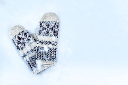 Knitted mittens in the snow. Winter, snow, cold conceptの写真素材