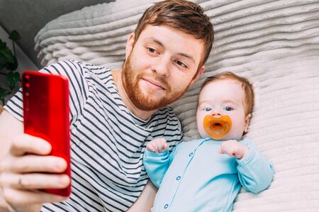 Man, child take a selfie in bedの写真素材
