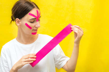 Portrait of a young woman with kinesio tapes on her face.の写真素材