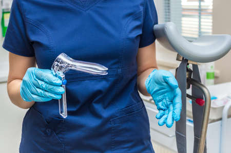 Gynecologist holding a gynecological speculum with glovesの写真素材