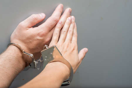 Hand of a man and a woman in metal handcuffs close-up. Codependency conceptの写真素材