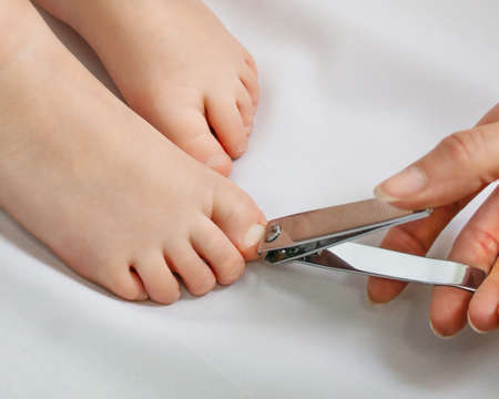 Cutting child nails on feet closeupの写真素材