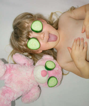 Little girl with a soft bear playing spaの写真素材