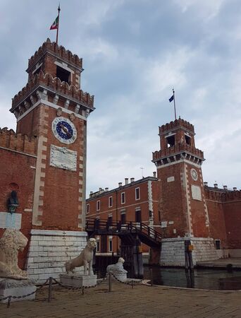 Venetian arsenal with wooden bridge under cloudy skyの写真素材