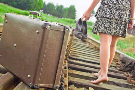 The girl on rails with a suitcaseの写真素材