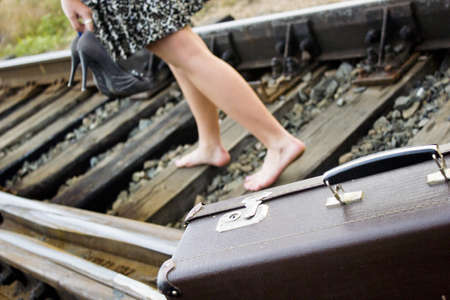The girl on rails with a suitcaseの写真素材