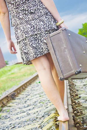 The girl on rails with a suitcaseの写真素材