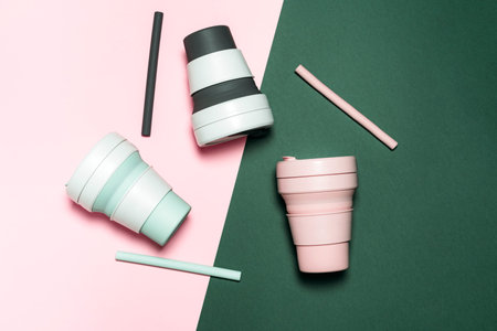 Top view of colorful eco cups for coffee on color trendy background. Pop art minimal flat lay style...