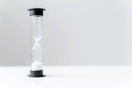 Hourglass on white table in office. Time management concept. Space for text.の写真素材