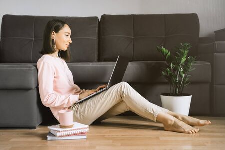 Young woman sitting on the floor and using laptop.の写真素材