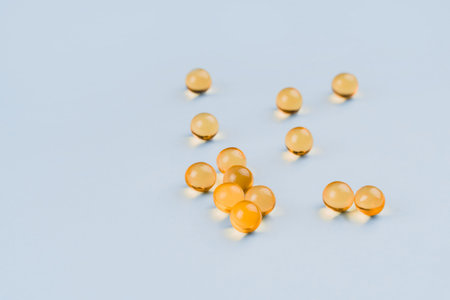 Omega 3 gel capsules on blue background.
