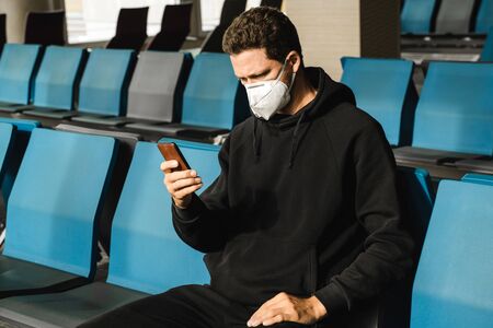 Man with respirator mask sitting in airport.の写真素材