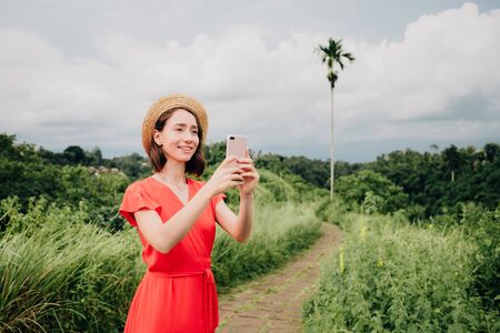 Young woman shooting photo or video for sharing media content to social networks.の写真素材