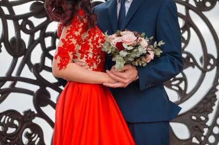 Close up of bride in red wedding dress, bridegroom and bridal bouquetの写真素材