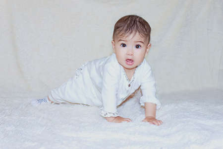 baby sitting on the fluffy white backgroundの写真素材