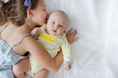 The girl kisses the little sisterの写真素材