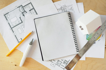 House remodel. The top view of a table of architects with the drawing of the house, with the paper...