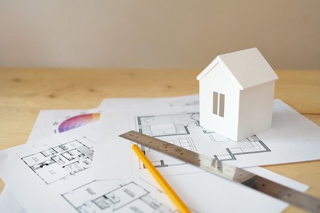 House remodel. The top view of a table of architects with the drawing of the house, with the paper model of the house, with a ruler and a pencil.の写真素材